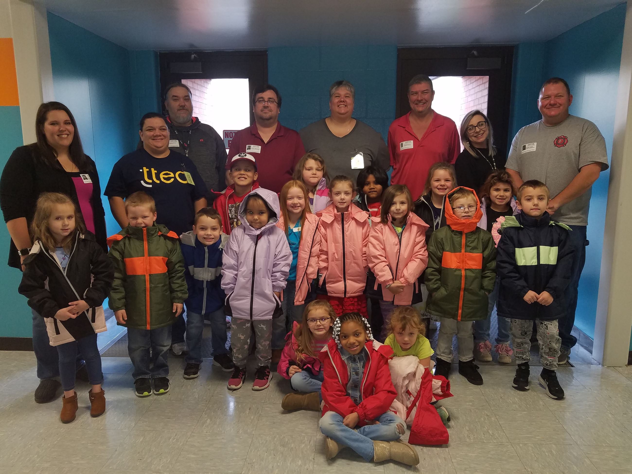 A photo of Local 313 Firefighters with children that received a coat from Operation Warm